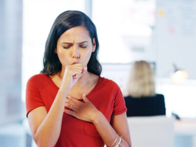 Woman, cough and chest pain in office, sick or cold with bronchitis, mucus or bacteria at media company. Person, ill and sore throat with flu or infection with bird flu virus at creative agency